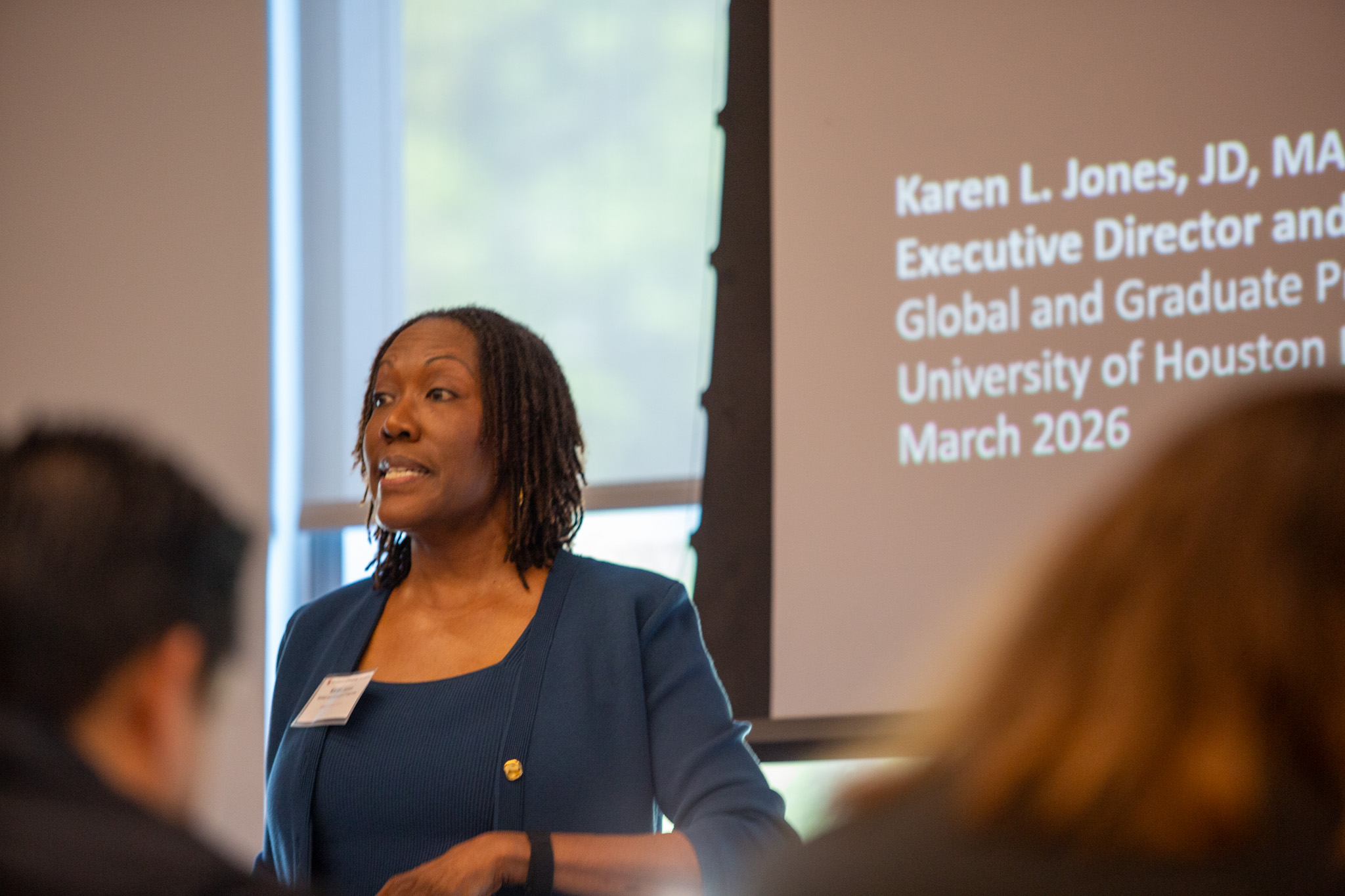 Speaker presenting at UH Law Center symposium with projected slide